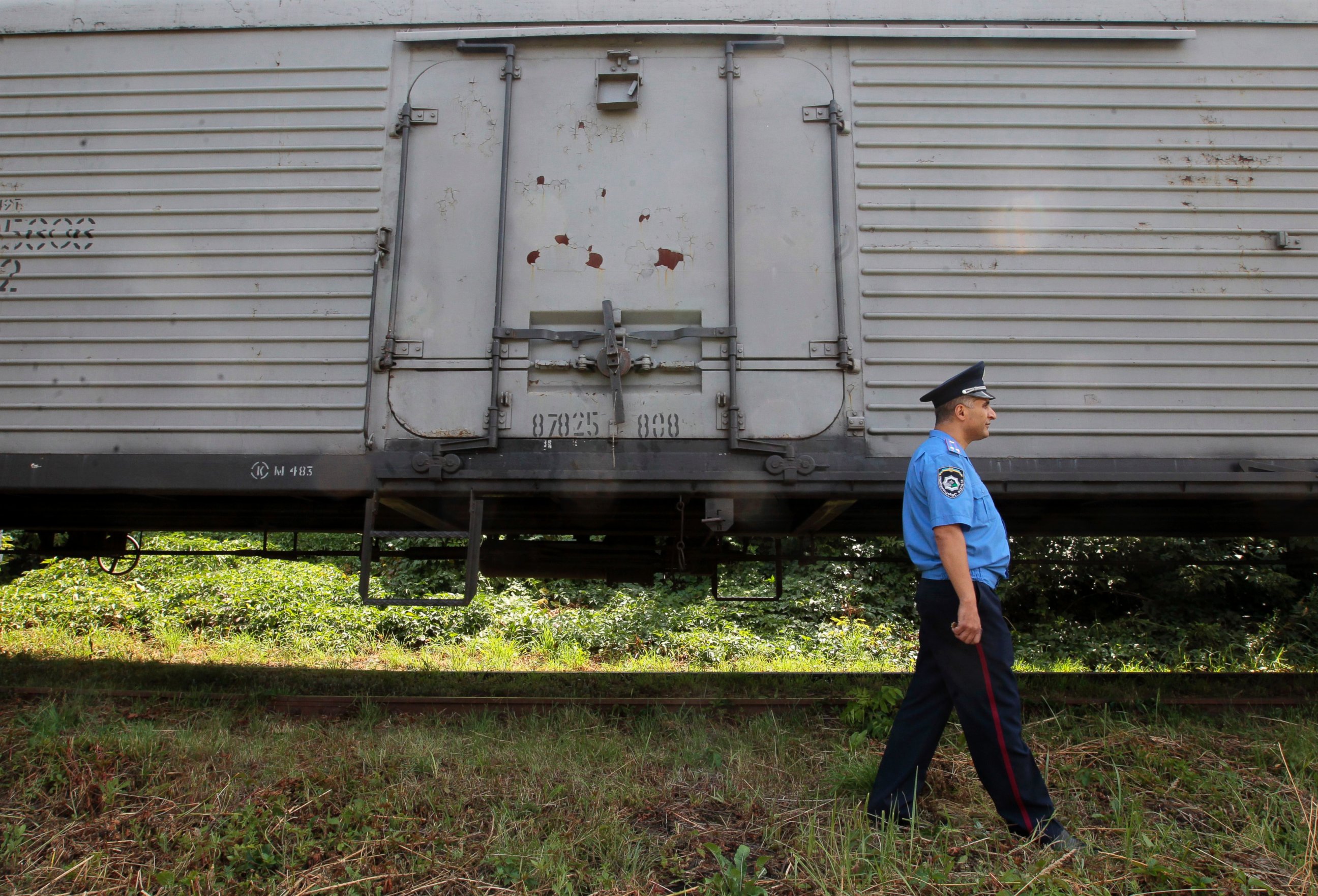 PHOTO: A police officer walks past a refrigerated train loaded with bodies of the passengers of Malaysian Airlines flight MH17 at Kharkiv railway station, Ukraine, July 22, 2014.