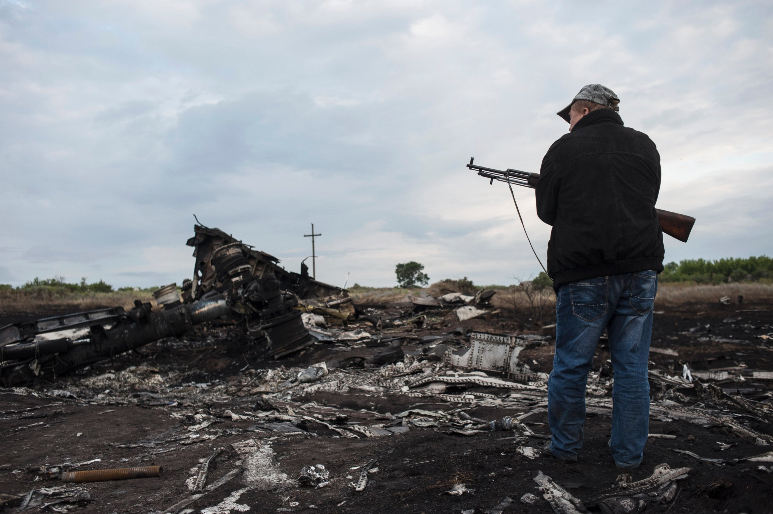 PHOTO: A pro-Russia fighter stands on guard the crash site of a Malaysia Airlines jet near the village of Hrabove, eastern Ukraine, Saturday, July 19, 2014. 