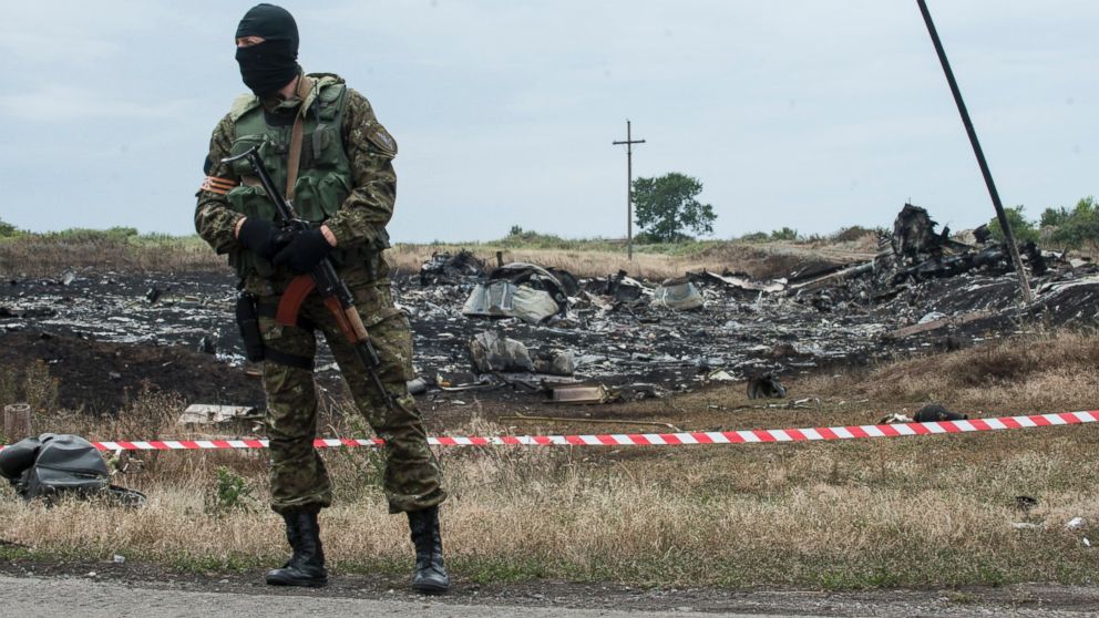 PHOTO: A pro-Russian fighter guards the crash site of a Malaysia Airlines jet near the village of Hrabove, eastern Ukraine, Saturday, July 19, 2014. 