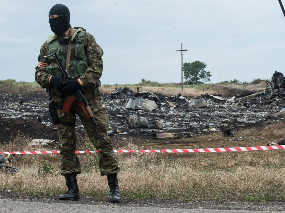 PHOTO: A pro-Russian fighter guards the crash site of a Malaysia Airlines jet near the village of Hrabove, eastern Ukraine, Saturday, July 19, 2014.