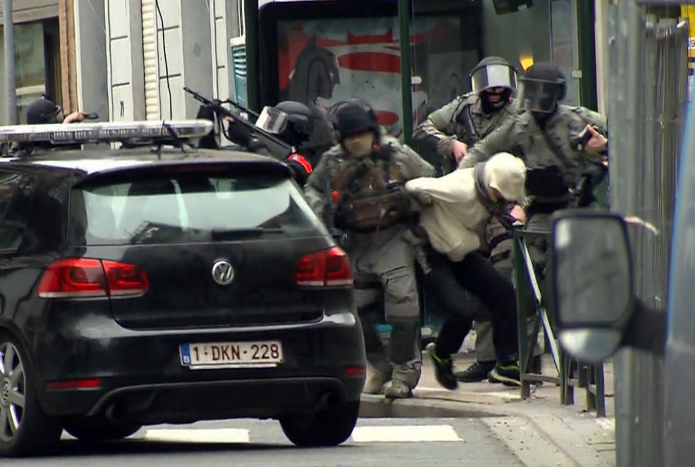 PHOTO: In this framegrab taken from VTM, armed police officers escort a suspect to a police vehicle during a raid in the Molenbeek neighborhood of Brussels,March 18, 2016.  