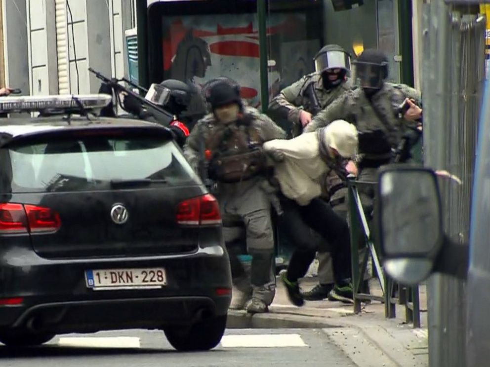PHOTO: In this framegrab taken from VTM, armed police officers escort a suspect to a police vehicle during a raid in the Molenbeek neighborhood of Brussels,March 18, 2016.