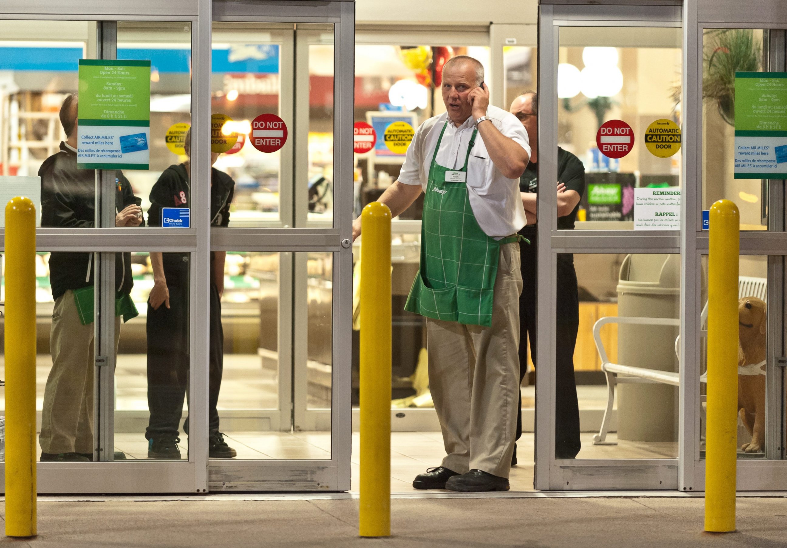 PHOTO: Employees of a grocery store lock down their store in Moncton, New Brunswick, June 4, 2014 following a shooting.