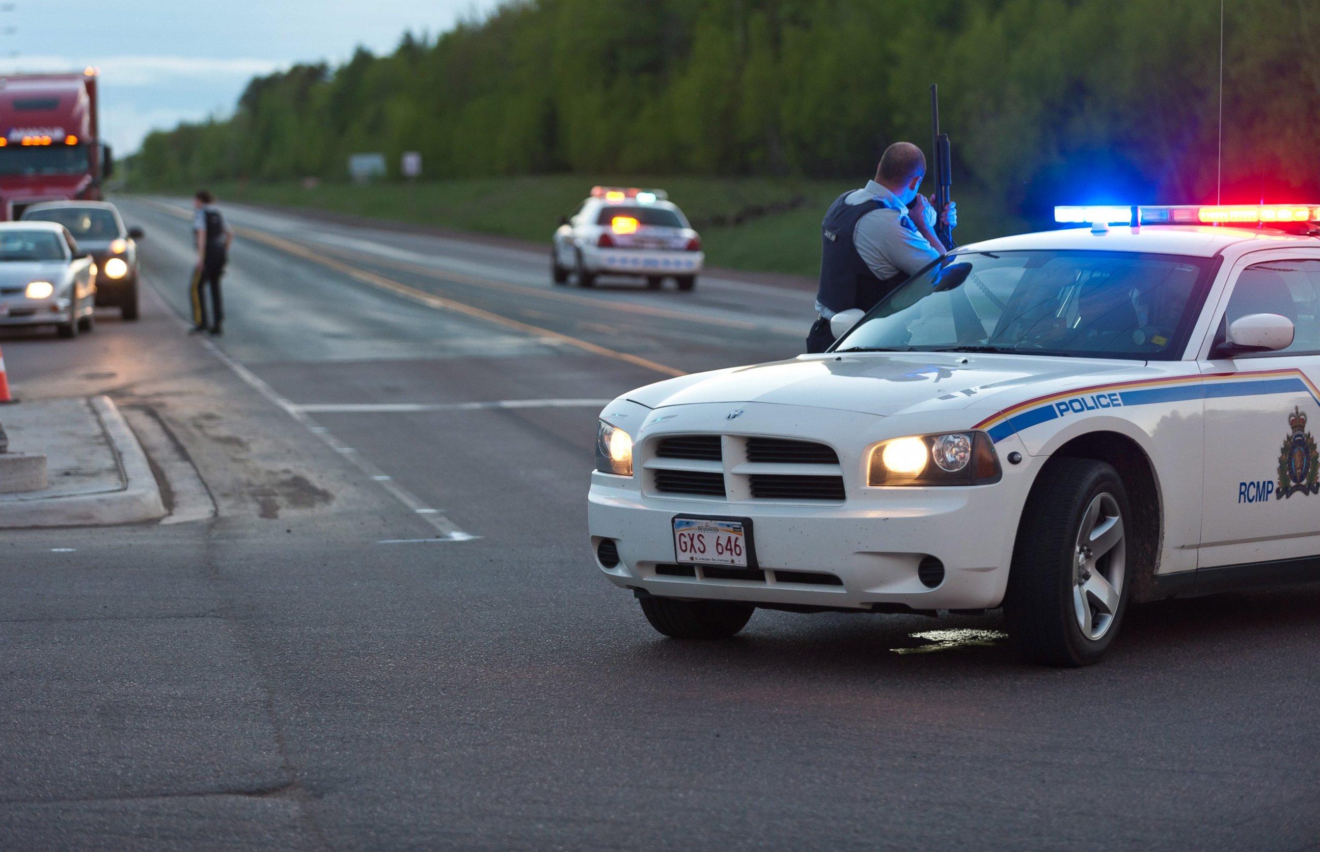 PHOTO: Royal Canadian Mounted Police officers use their vehicles to create a keep a perimeter in Moncton, New Brunswick, June 4, 2014, following a shooting.