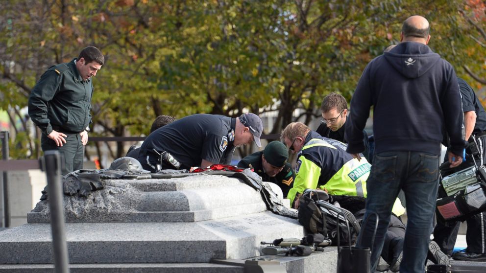 Emergency personnel tend to a soldier shot at the National Memorial near Parliament Hill in Ottawa, Oct. 22, 2014.
