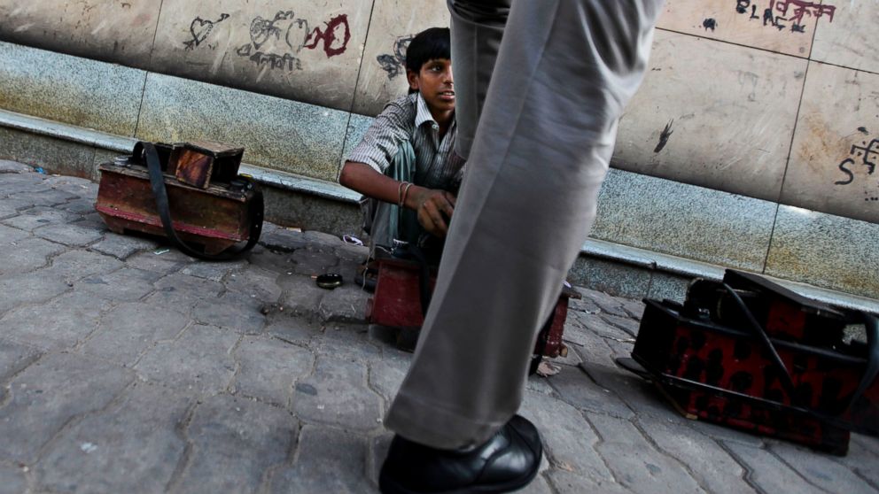 PHOTO: A young Indian boy polishes a shoe on a pavement on World Day Against Child Labor in New Delhi, India, June 12, 2012.