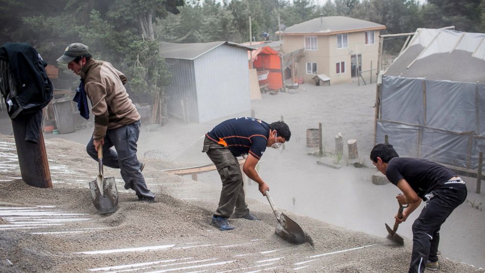 PHOTO: Men remove ash from a building's roof, left by the Calbuco volcano, in Ensenada, Chile, April 23, 2015. 