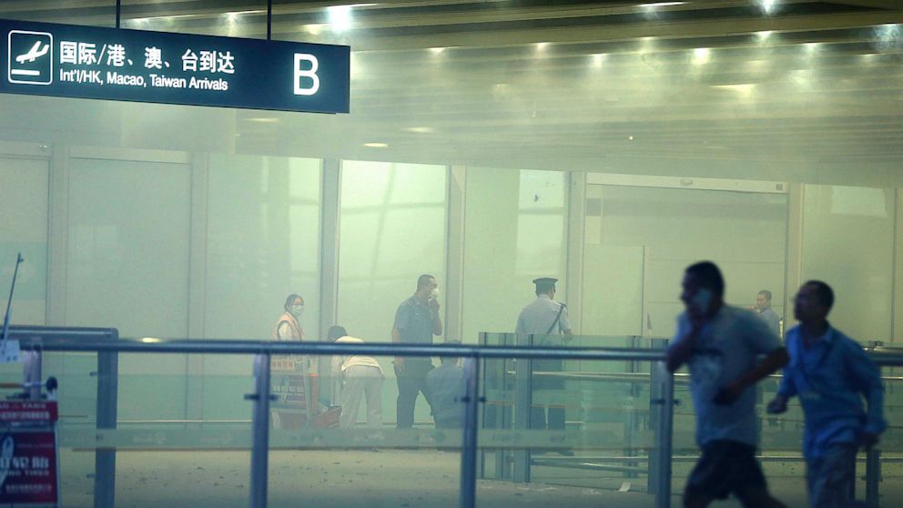 In this photo released by China's Xinhua News Agency, medical workers and policemen work at the terminal 3 of the Beijing International Airport in Beijing, Saturday, July 20, 2013. Chinese state media said that a man set off a homemade bomb in Terminal 3 of the Beijing International Airport, but that no one besides the man was injured and order has been restored. 