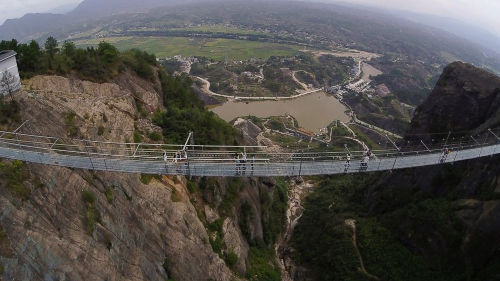 Visitors walk across a glass-bottomed suspension bridge as seen from the air in a scenic zone in Pingjiang county in southern China's Hunan province, Sept. 24, 2015.