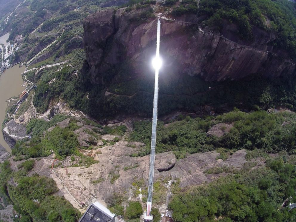 PHOTO: Sunlight reflects off a glass-bottomed suspension bridge as seen from the air in a scenic zone in Pingjiang county in southern China's Hunan province, Sept. 24, 2015.