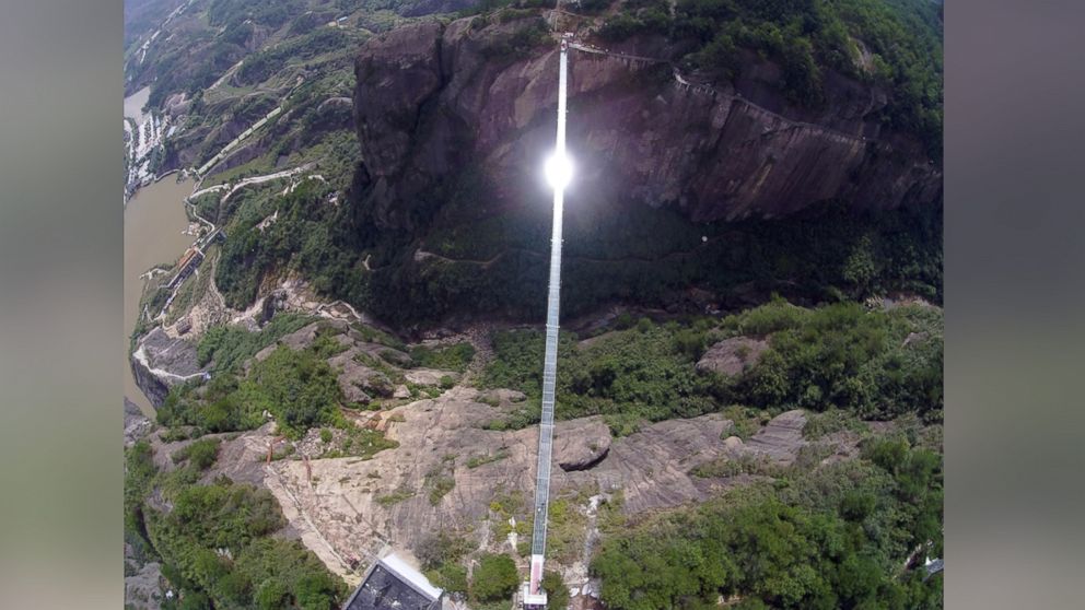 PHOTO: Sunlight reflects off a glass-bottomed suspension bridge as seen from the air in a scenic zone in Pingjiang county in southern China's Hunan province, Sept. 24, 2015.