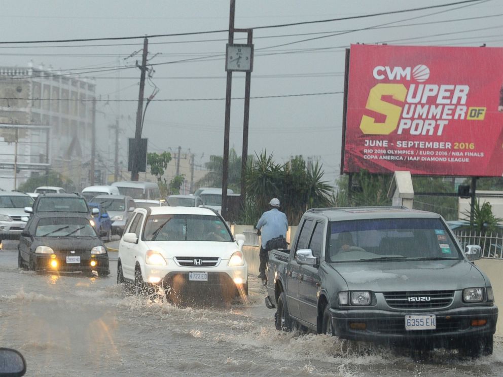 PHOTO: Cars drive along a street under heavy rain in downtown Kingston, Jamaica, Oct. 2, 2016.