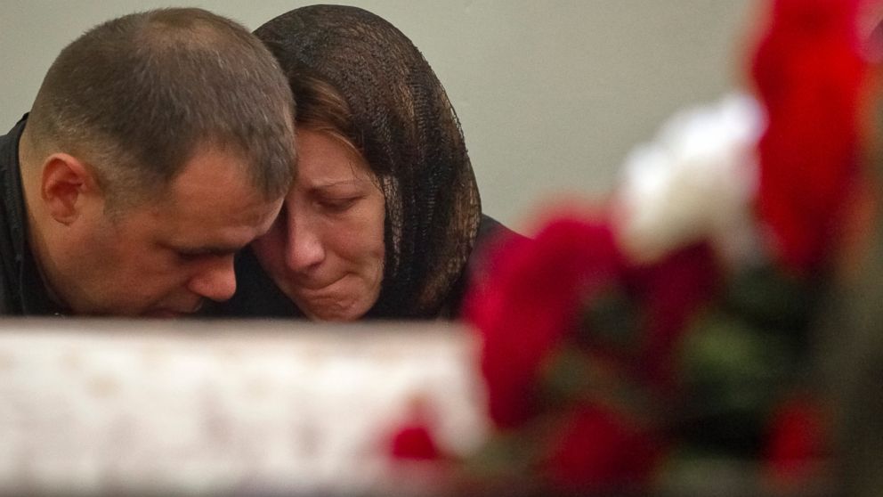 PHOTO: Relatives of Ukrainian soldier Sergey Kokurin, 35, mourn next to his coffin during his funeral in Simferopol, Crimea, Saturday, March 22, 2014. 