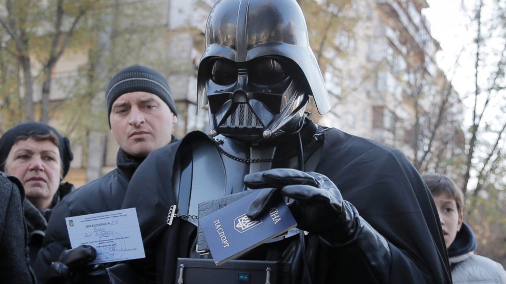 PHOTO: Darth Vader, previously known as Viktor Shevchenko, the leader of the Ukrainian Internet Party, holds up his Ukrainian passport and a certificate of candidacy for the parliamentary election at a polling station in Kiev, Ukraine, Oct. 26, 2014.