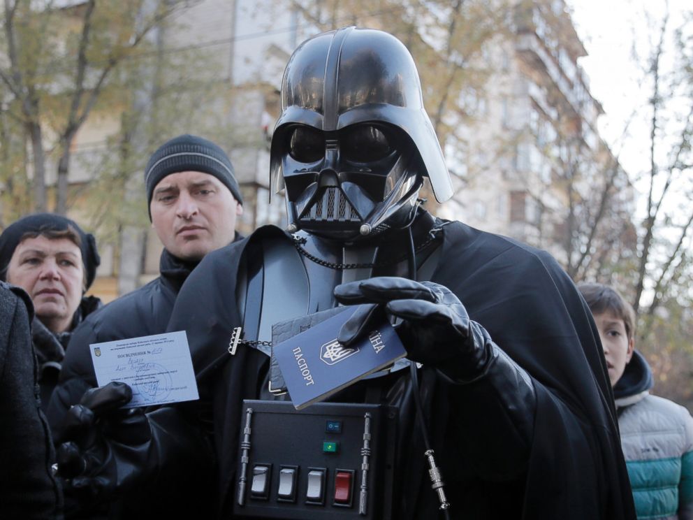 PHOTO: Darth Vader, previously known as Viktor Shevchenko, the leader of the Ukrainian Internet Party, holds up his Ukrainian passport and a certificate of candidacy for the parliamentary election at a polling station in Kiev, Ukraine, Oct. 26, 2014.