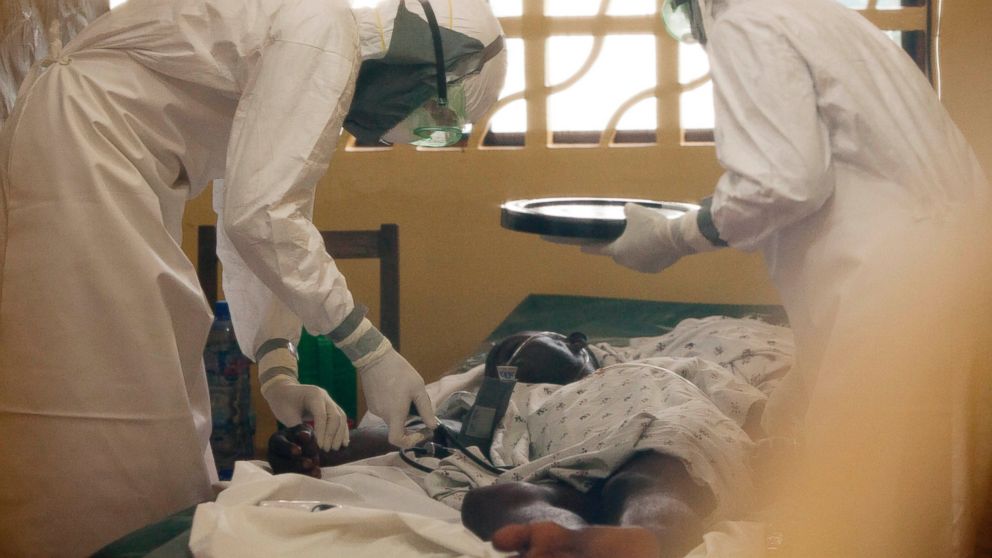 Dr. Kent Brantly, seen at left treating an Ebola patient in Liberia this year, has now become one of two Americans known to have been infected with the disease.