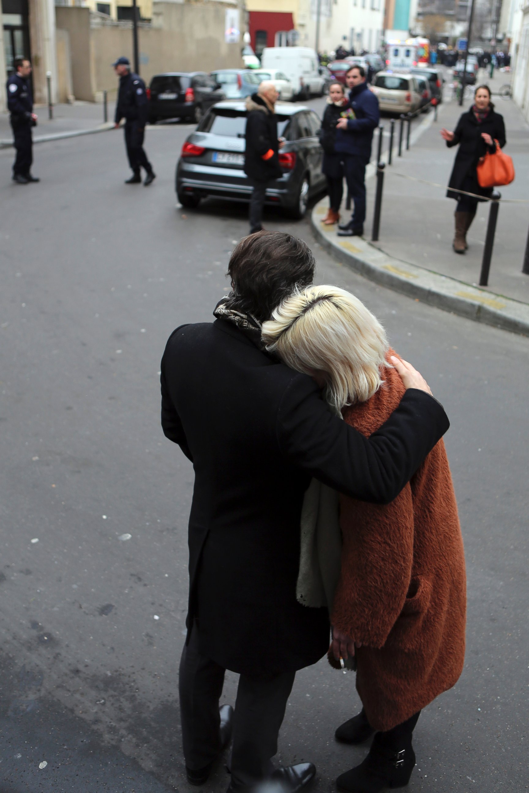 PHOTO: People stand outside the French satirical newspaper Charlie Hebdo's office after a shooting, in Paris, Jan. 7, 2015. 