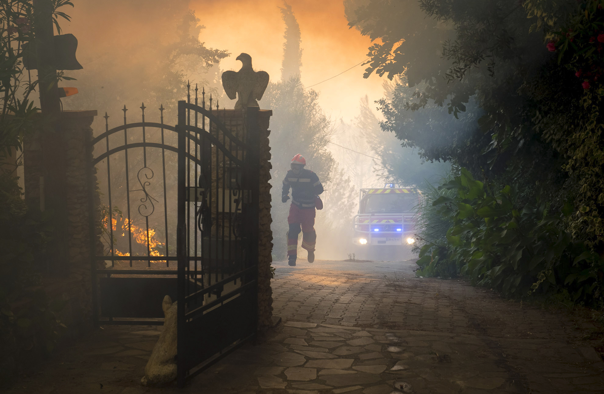 PHOTO: This photo provided by the Bataillon des Pompiers de Marseille (BMPM), shows a firefighter running past a fire near Marseille, Southern France, Aug.10, 2016.
