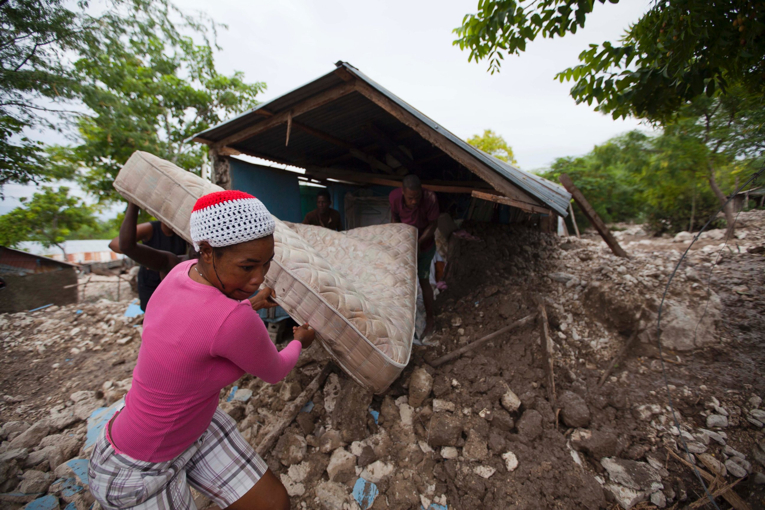 PHOTO: Residents salvage a mattress from a home partially submerged in mud from a mudslide triggered by Tropical Storm Erika, Aug. 29, 2015, in Montrouis, Haiti.