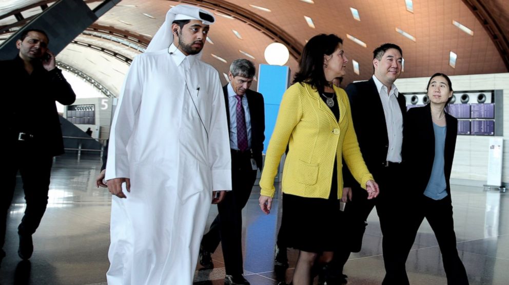 From right, Grace and Matthew Huang walk to their gate with U.S. Ambassador to Qatar Dana Shell Smith, at the Hamad International Airport in Doha, Qatar, Nov. 30, 2014.