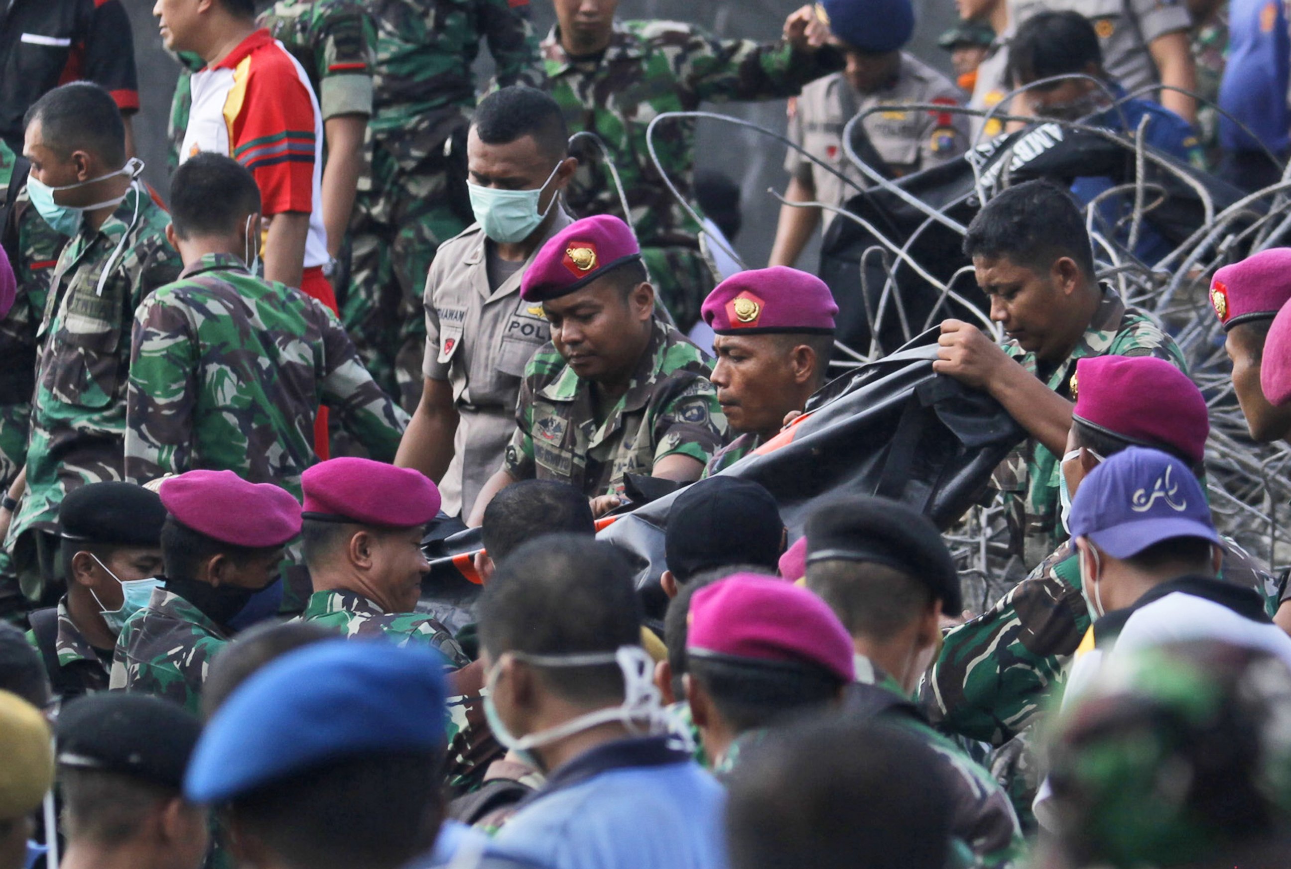 PHOTO: Indonesian military personnel carry a body bag containing the body of a victim at the site where an air force cargo plane crashed in Medan, North Sumatra, Indonesia,  June 30, 2015.