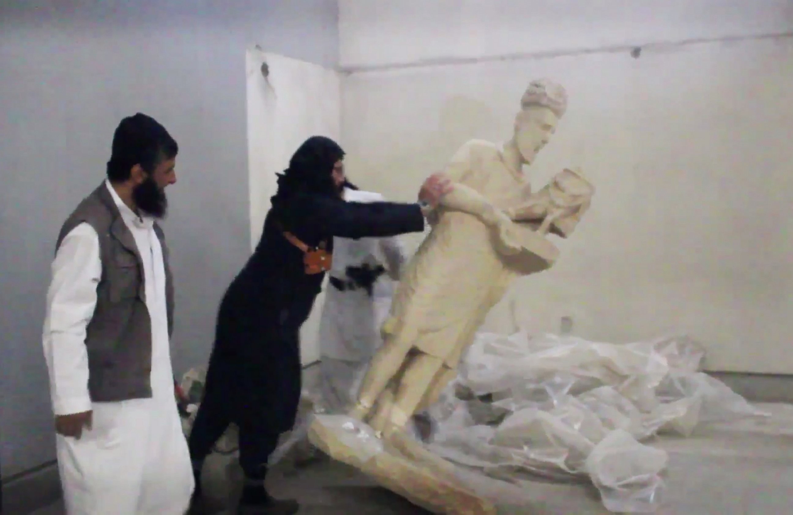 PHOTO: A militant topples an ancient artifact in the Ninevah Museum in Mosul, Iraq, in this screengrab from a video posted on a social media account affiliated with the Islamic State group on Feb. 26, 2015.