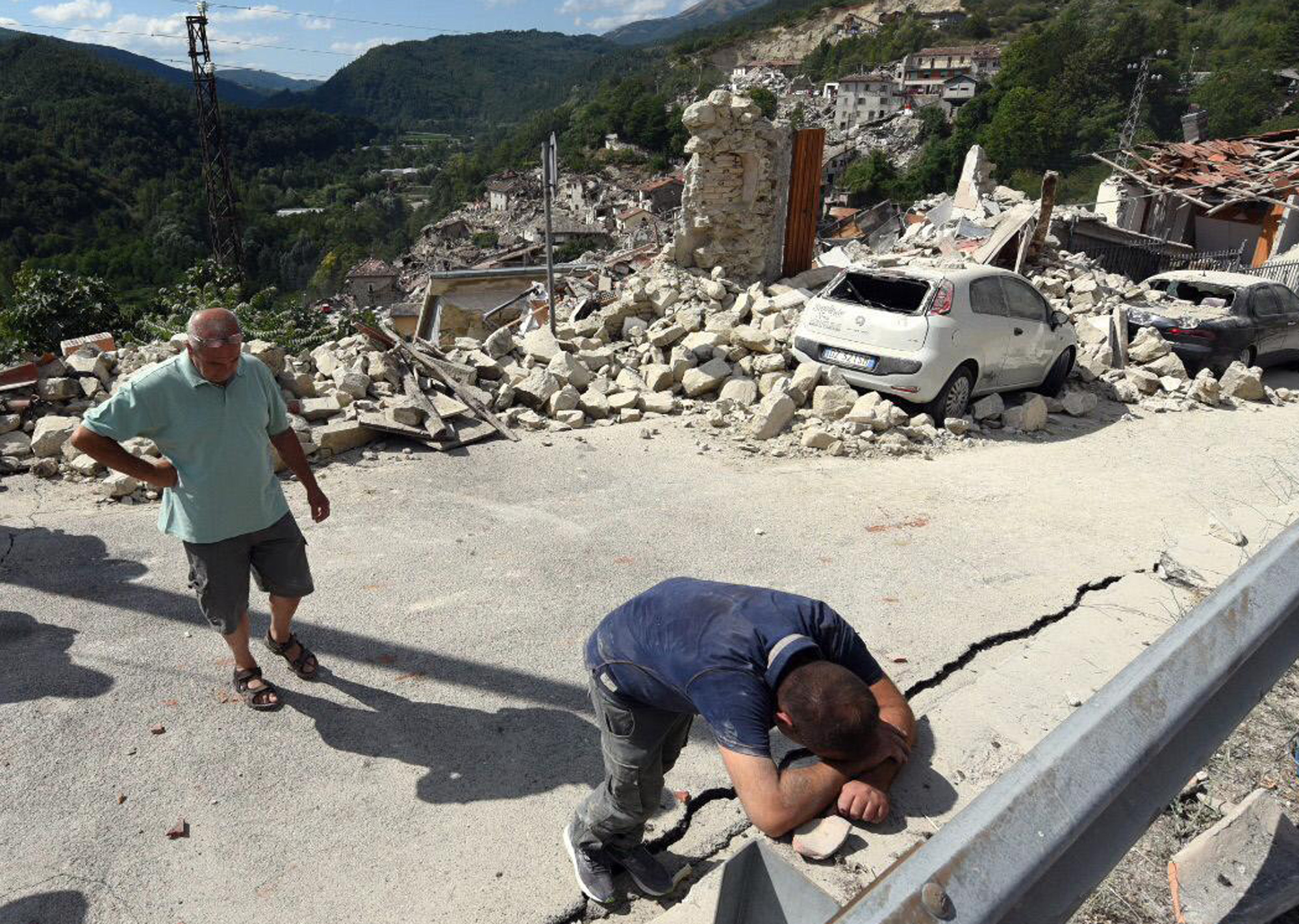 PHOTO: A man leans on a wall as the collapsed village of Pescara del Tronto, Italy, is seen behind him, Aug. 24 2016 following an earthquake.