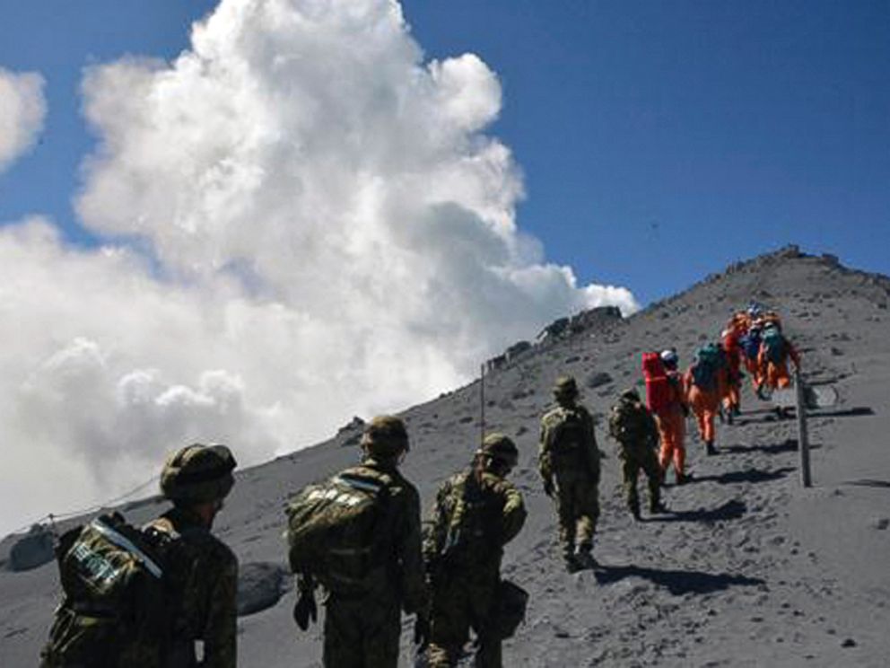PHOTO: JGSDF personnel and fire fighters head for the summit of Mount Ontake to rescue people who have been trapped in the mountaintop lodge one day after the volcano became active in central Japan, Sept. 28, 2014.
