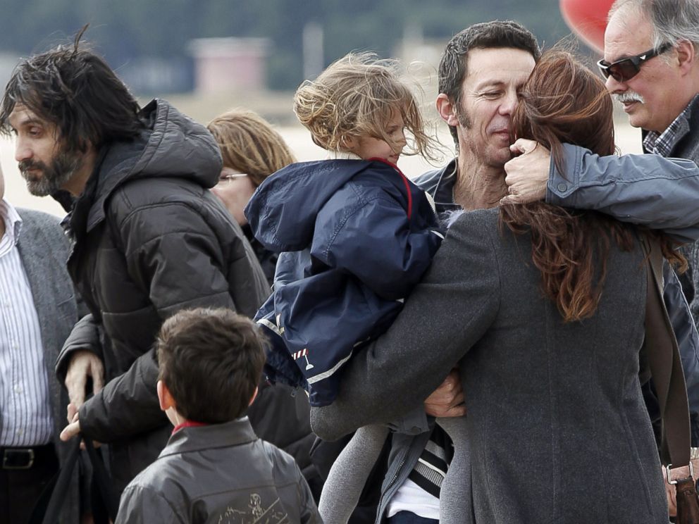 PHOTO: Spanish reporter Javier Espinosa, second right, holds his daughter Nur as he is greeted by his wife Monica Garcia upon his arrival at the military airport of Torrejon in Madrid, Sunday, March 30, 2014.