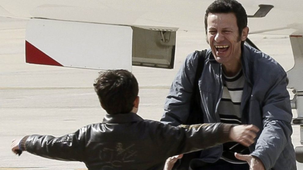 Spanish reporter Javier Espinosa, reacts as his son Yerai runs towards him upon his arrival at the military airport of Torrejon in Madrid, Sunday, March 30, 2014. 