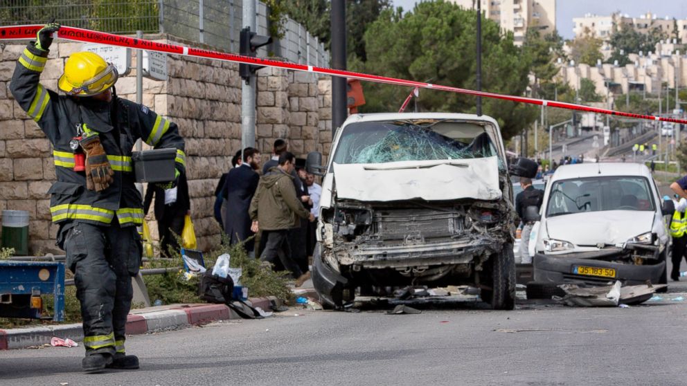 An Israeli fire fighter walks at the scene of an attack in Jerusalem, Nov. 5, 2014.