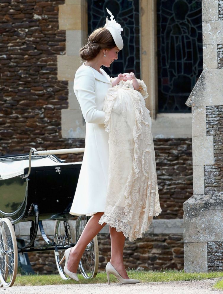 PHOTO: Britain's Kate the Duchess of Cambridge carries Princess Charlotte after taking her out of a pram as they arrive for Charlotte's Christening at St. Mary Magdalene Church in Sandringham, England, July 5, 2015.