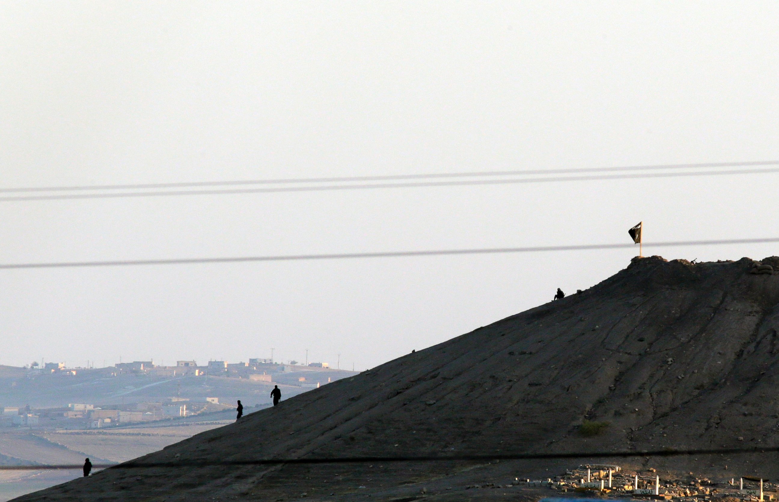 PHOTO: Militants with the Islamic State group are seen after placing their group's flag on a hilltop at the eastern side of the town of Kobani, Syria, Oct. 6, 2014.