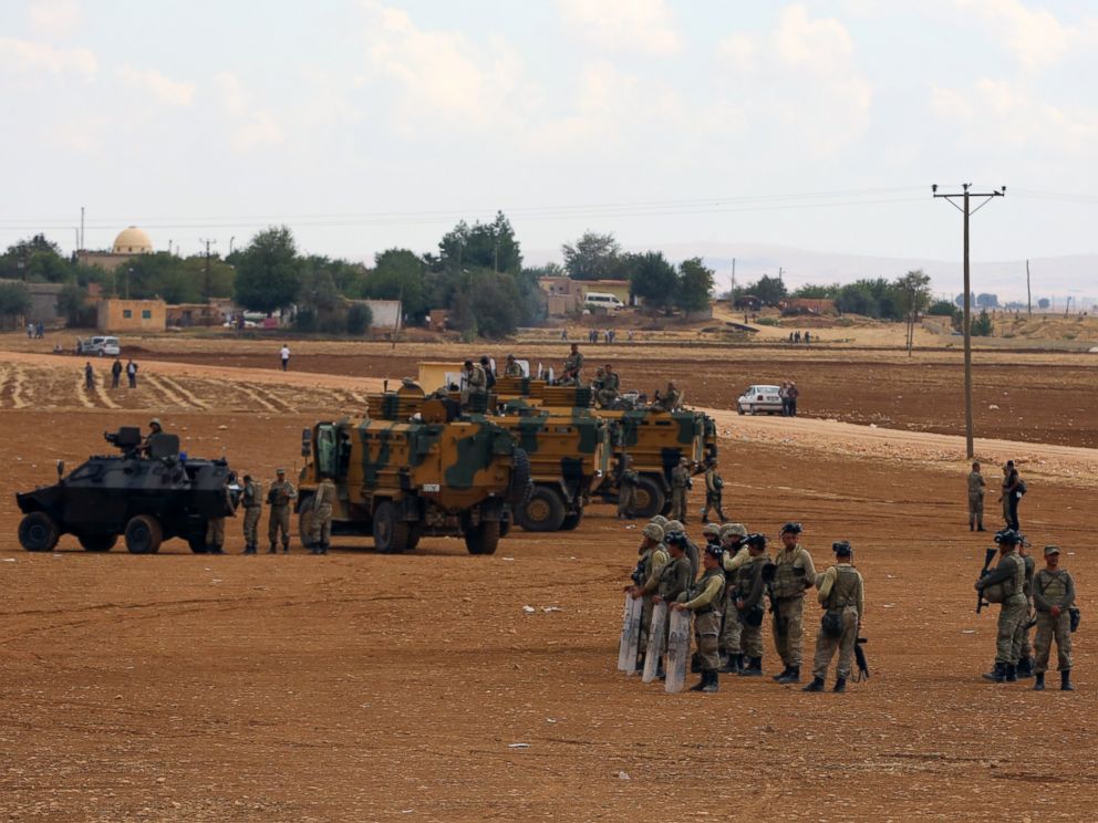 PHOTO: Turkish soldiers standby as Turkish Kurds gather nearby to express their solidarity with Kurdish fighters in Kobani, Syria, at the Turkey-Syria border near Suruc, Turkey, Sept. 29, 2014.
