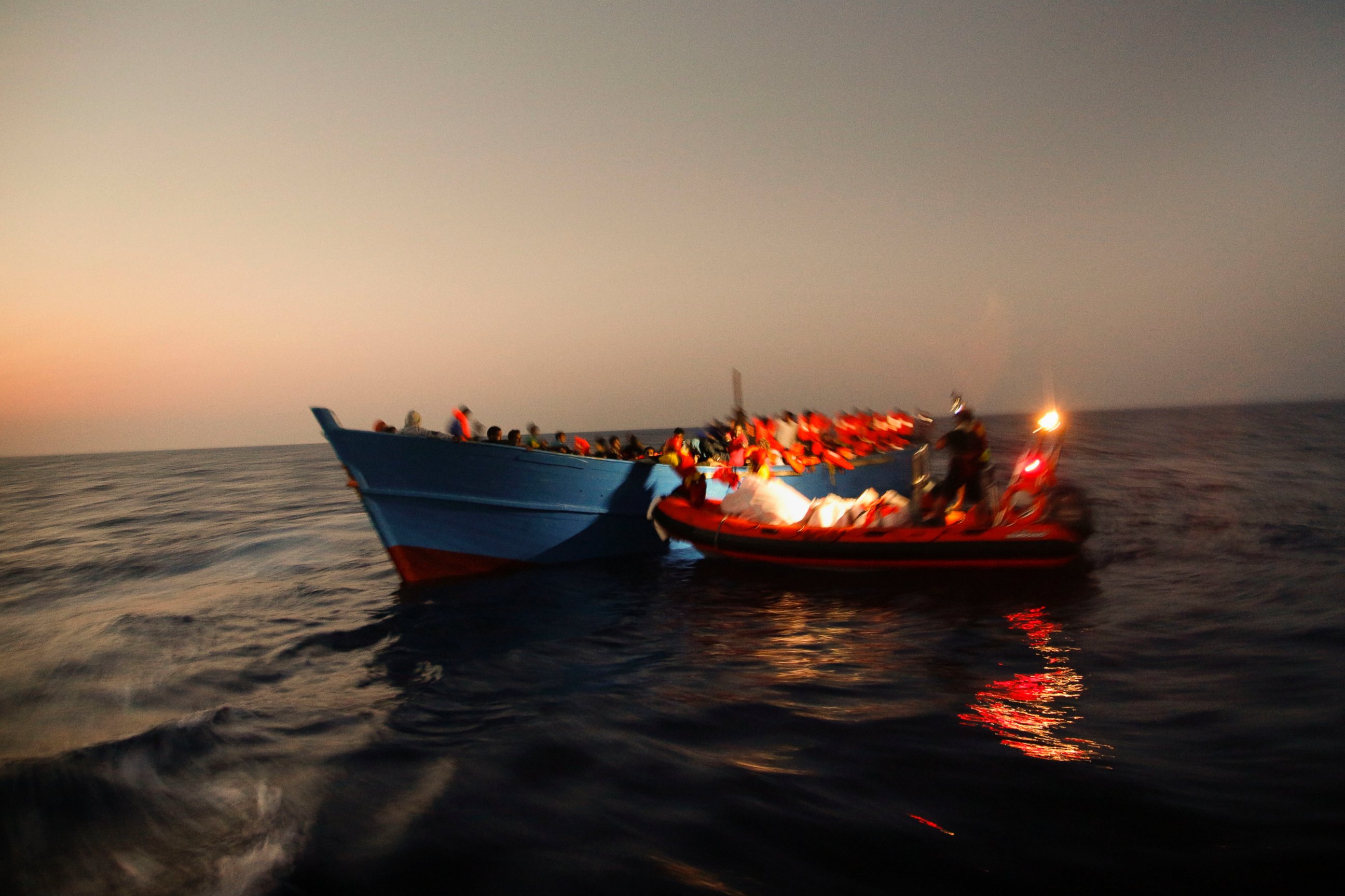 PHOTO: Migrants sailing in a crowded wooden boat carrying more than seven hundred migrants, are helped by members of an NGO  during a rescue operation at the Mediterranean sea, about 13 miles north of Sabratha, Libya, Aug. 29, 2016.