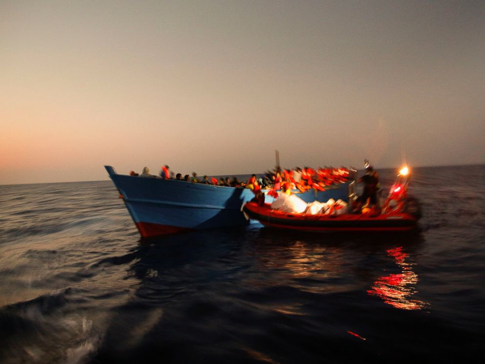 PHOTO: Migrants sailing in a crowded wooden boat carrying more than seven hundred migrants, are helped by members of an NGO during a rescue operation at the Mediterranean sea, about 13 miles north of Sabratha, Libya, Aug. 29, 2016.