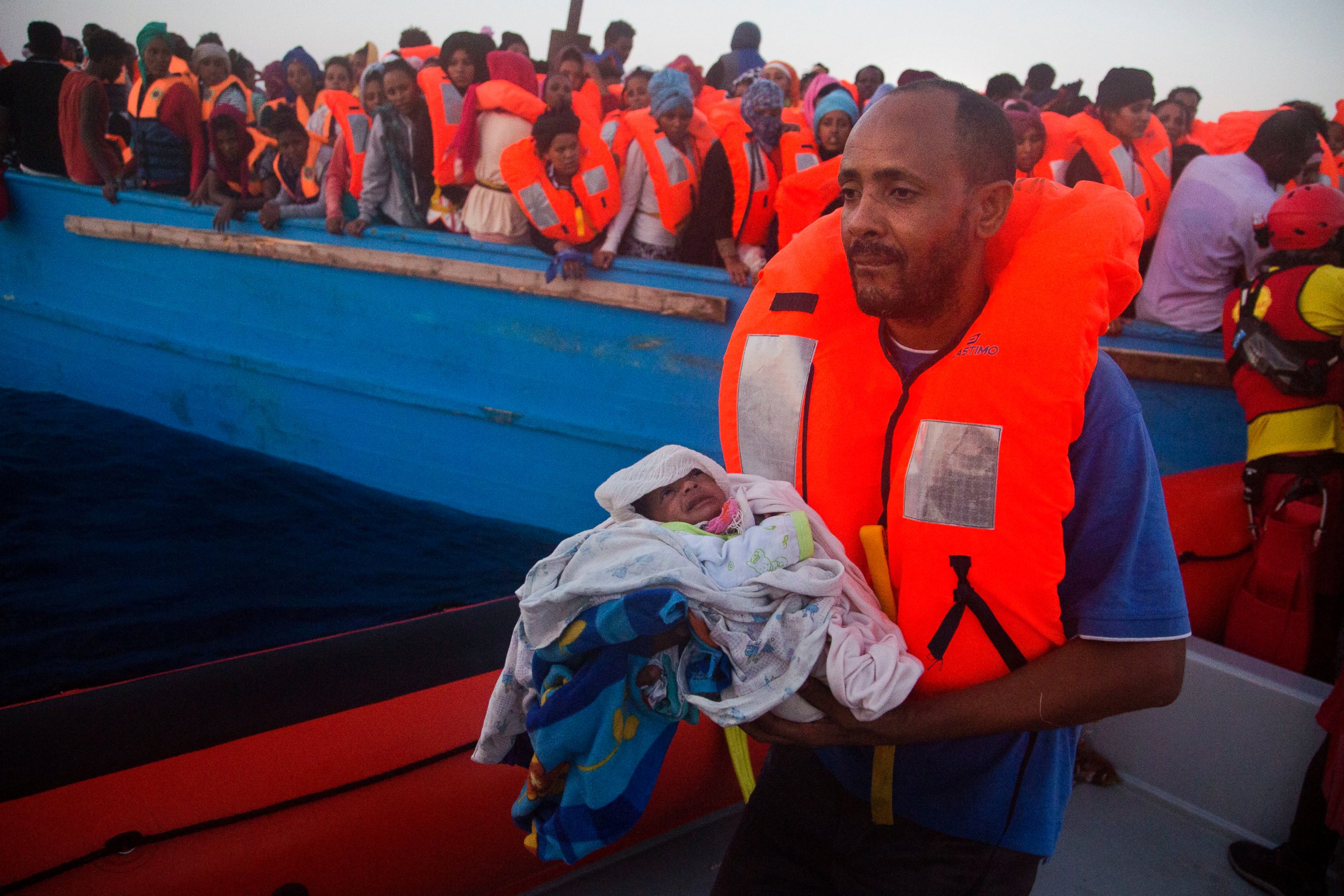 PHOTO: A man carries his five-day-old son after been rescued from a crowded wooden vessel as they were fleeing Libya during a rescue operation in the Mediterranean sea, Aug. 29, 2016. 