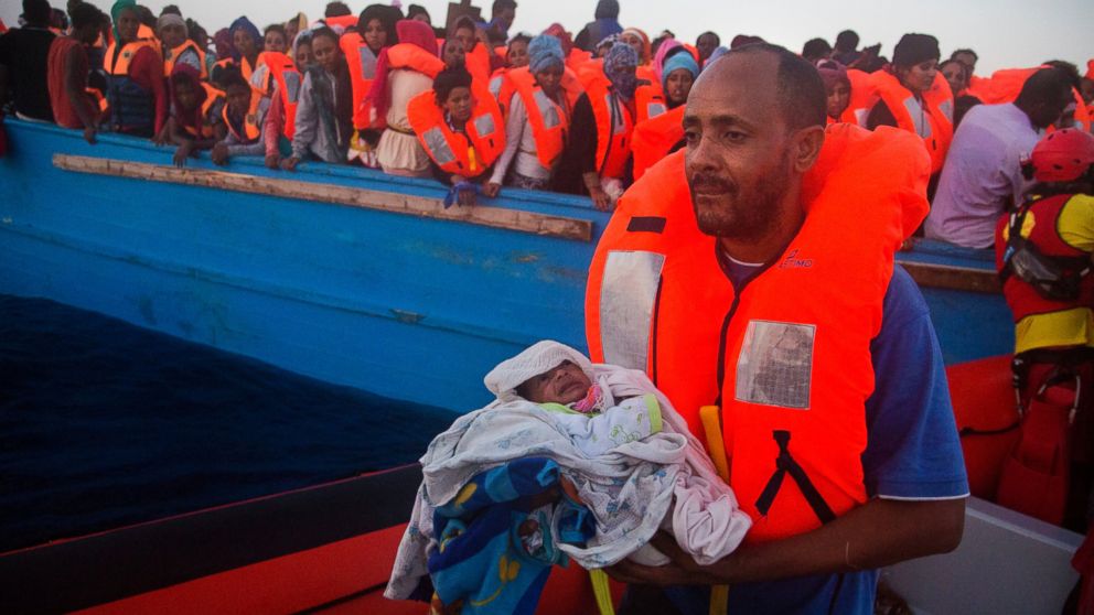 A man carries his five-day-old son after been rescued from a crowded wooden vessel as they were fleeing Libya during a rescue operation in the Mediterranean sea, Aug. 29, 2016.
