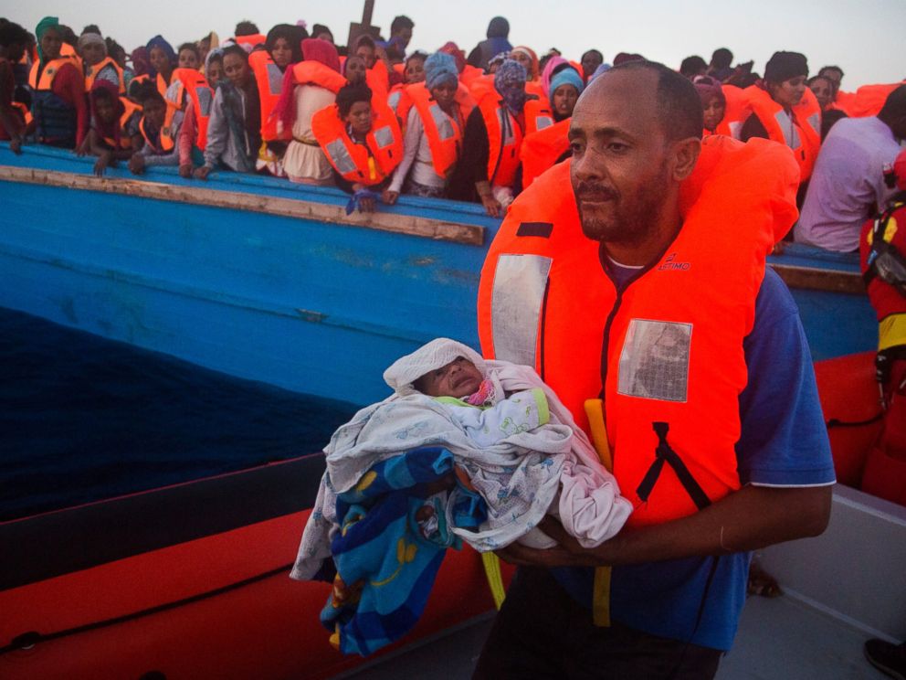 PHOTO: A man carries his five-day-old son after been rescued from a crowded wooden vessel as they were fleeing Libya during a rescue operation in the Mediterranean sea, Aug. 29, 2016.