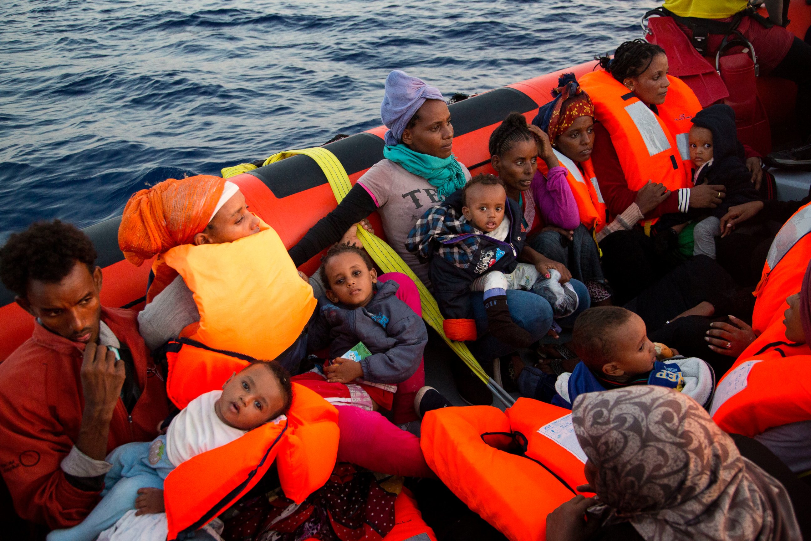 PHOTO: Migrants from Eritrea hold their children after been rescued from a crowded wooden boat as they were fleeing Libya, about 13 miles north of Sabratha, Libya, Aug. 29, 2016. 