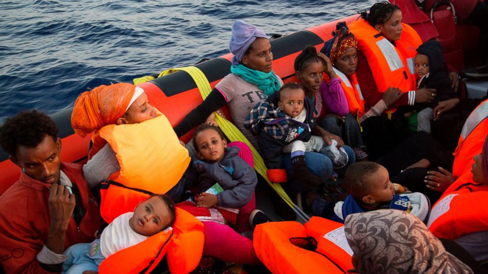 Migrants from Eritrea hold their children after been rescued from a crowded wooden boat as they were fleeing Libya, about 13 miles north of Sabratha, Libya, Aug. 29, 2016.