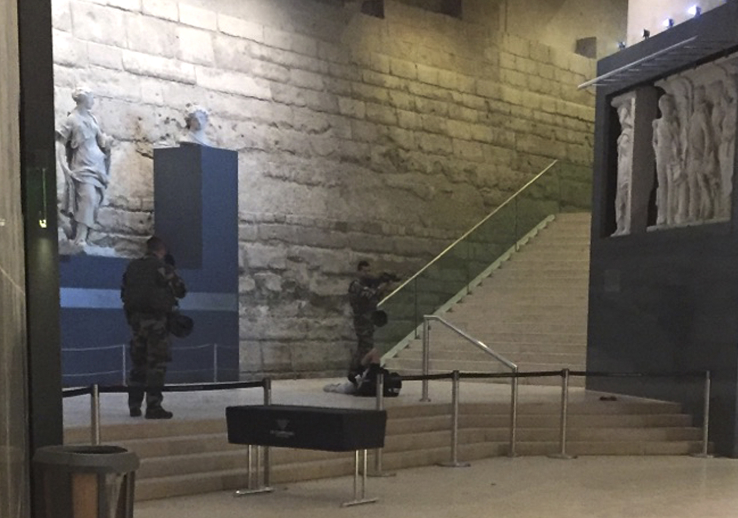 PHOTO: The body of a man lays on the floor as two soldiers guard him in the Louvre museum, Feb. 3, 2017 in Paris. 