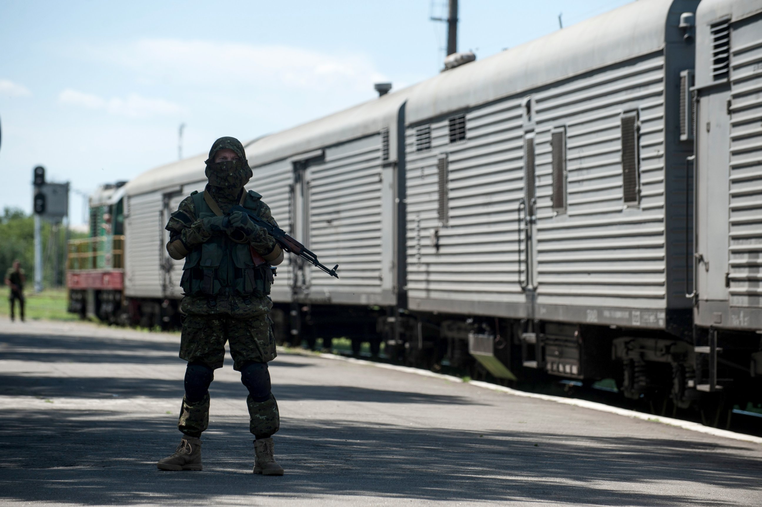 PHOTO: A pro-Russian armed fighter stands in guard on the platform as a refrigerated train loaded with bodies of the passengers departs the station in Torez, Ukraine, near the crash site of Malaysia Airlines Flight 17, July 21, 2014.