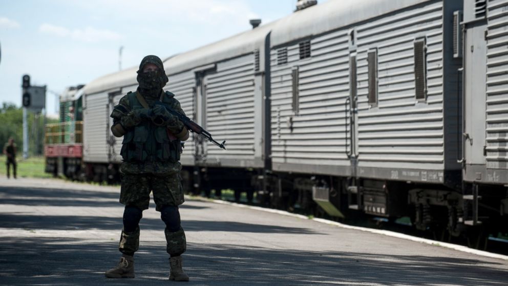 PHOTO: A pro-Russian armed fighter stands in guard on the platform as a refrigerated train loaded with bodies of the passengers departs the station in Torez, Ukraine, near the crash site of Malaysia Airlines Flight 17, July 21, 2014.