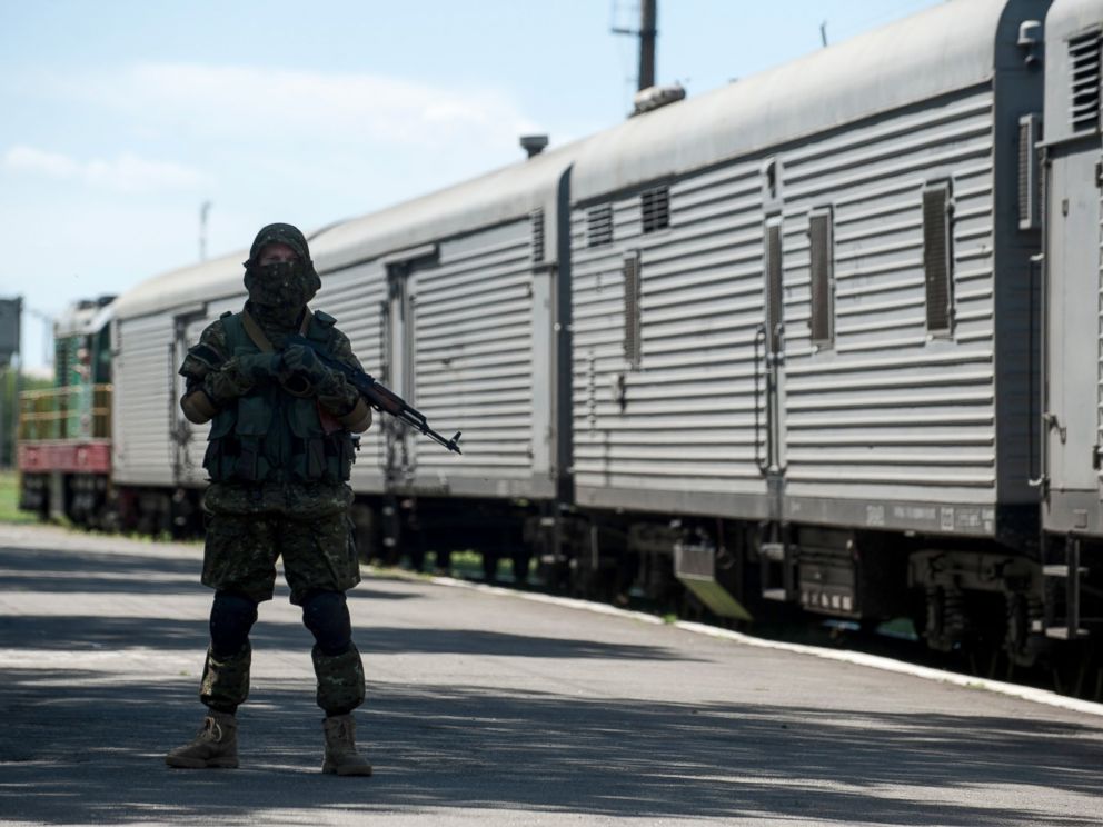 PHOTO: A pro-Russian armed fighter stands in guard on the platform as a refrigerated train loaded with bodies of the passengers departs the station in Torez, Ukraine, near the crash site of Malaysia Airlines Flight 17, July 21, 2014.