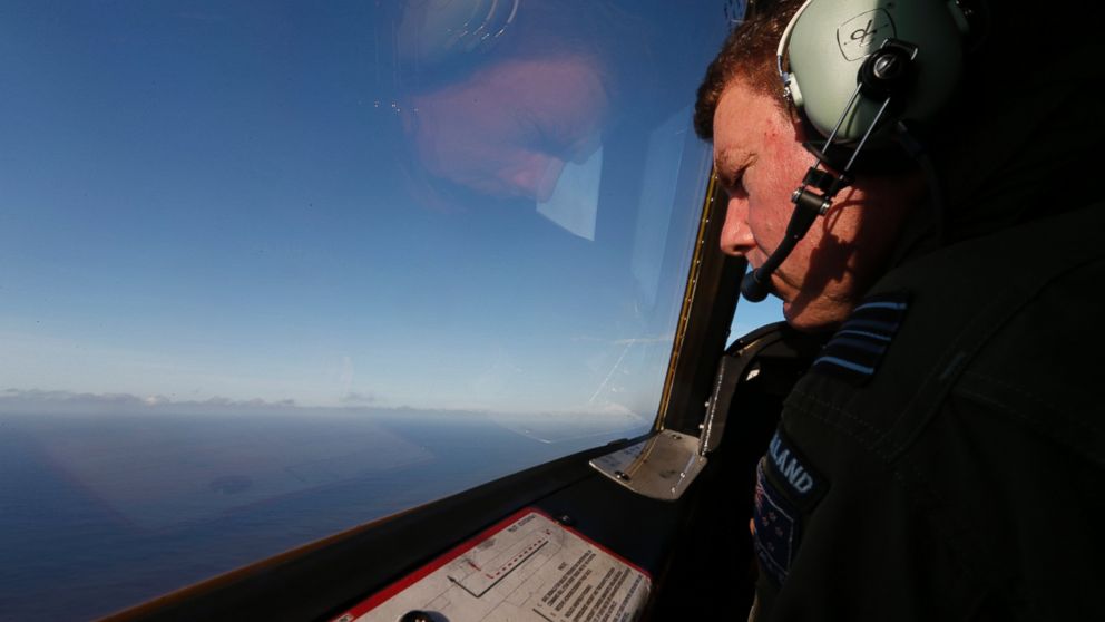 Royal New Zealand Air Force P-3K2 Orion co-pilot Brett McKenzie looks out from the cockpit for the missing Malaysian Airlines flight 370 over the southern Indian Ocean, Saturday, March 29, 2014.