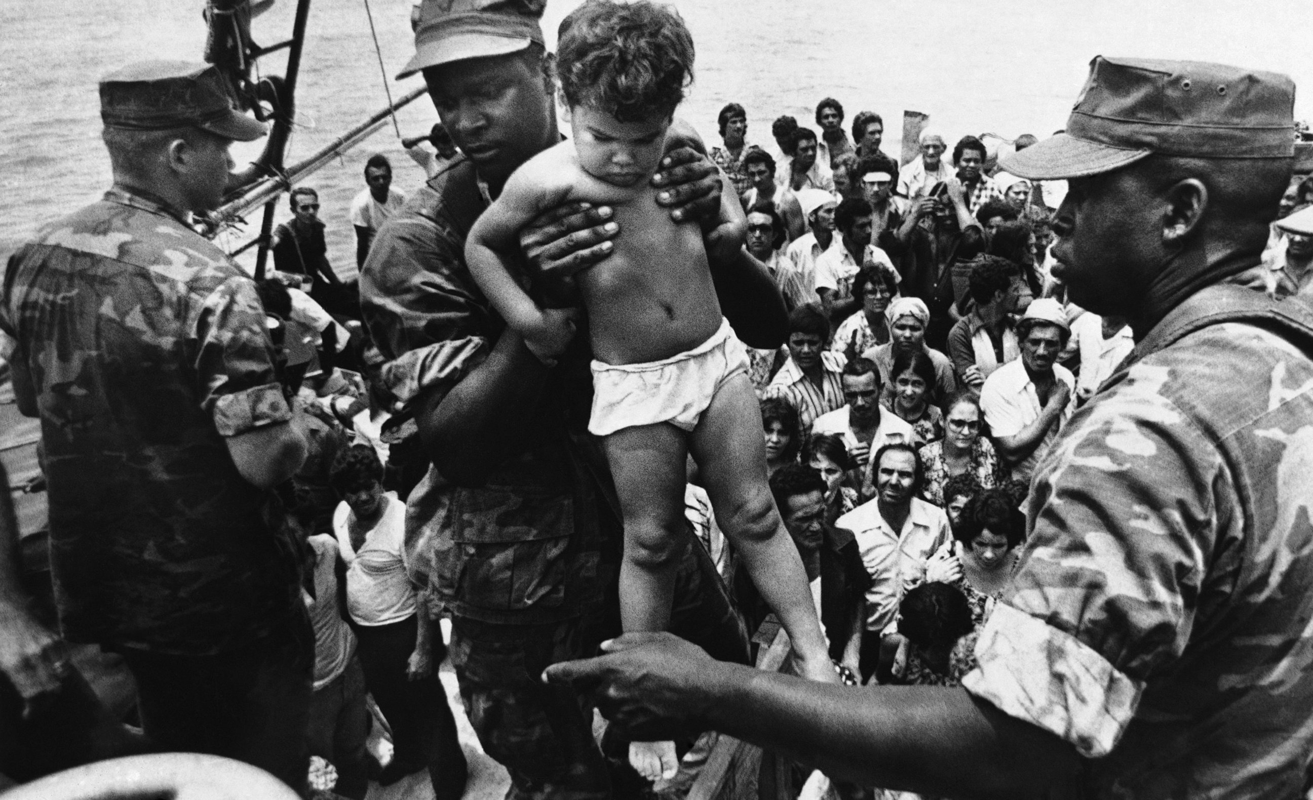 PHOTO: In 1980, Fidel Castro opened up the Mariel port in Cuba for residents to leave.  A U.S. Marine helped a young Cuban child off one of the refugee boats poured into Key West for weeks, May 10, 1980.  