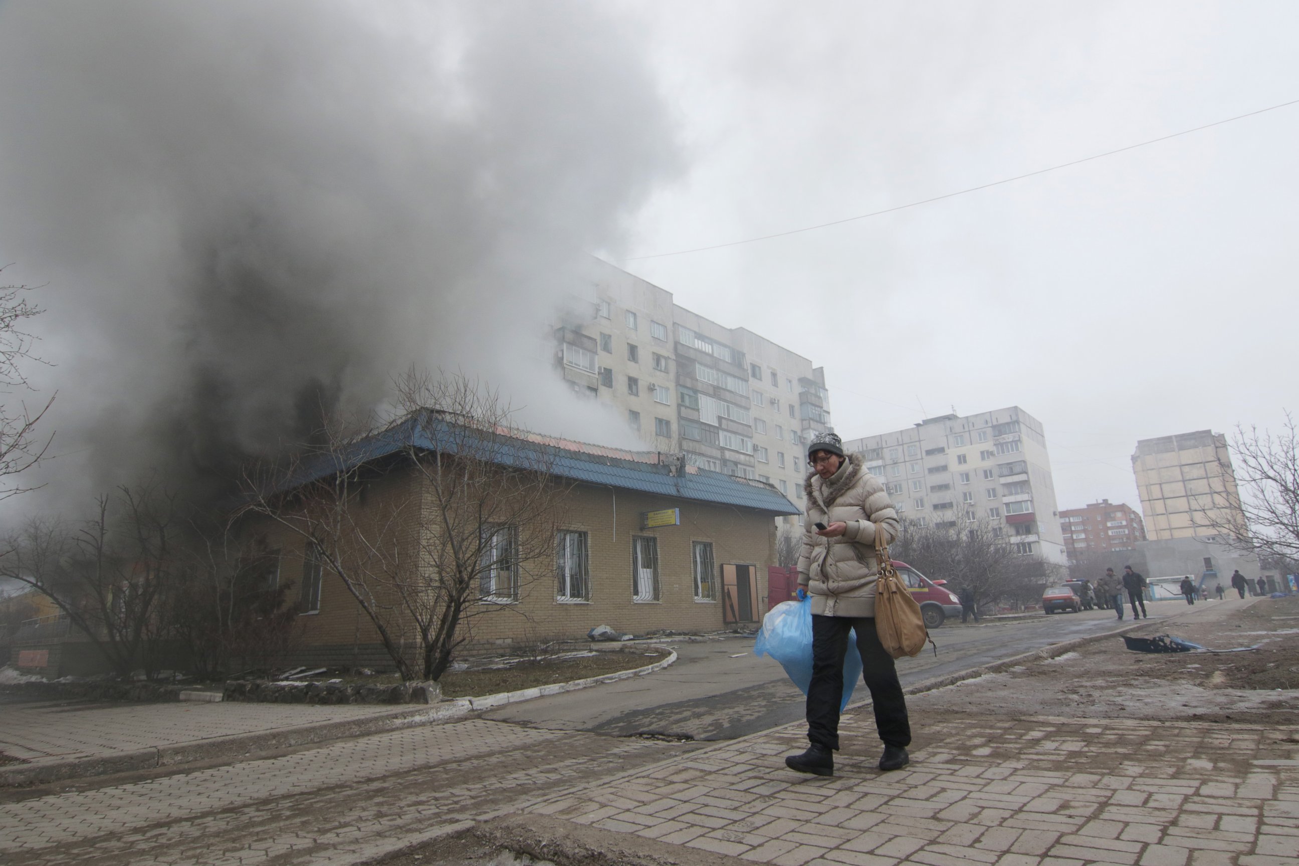 PHOTO: A woman resident passes by a burning house in Mariupol, Ukraine, Saturday, Jan. 24, 2015. 