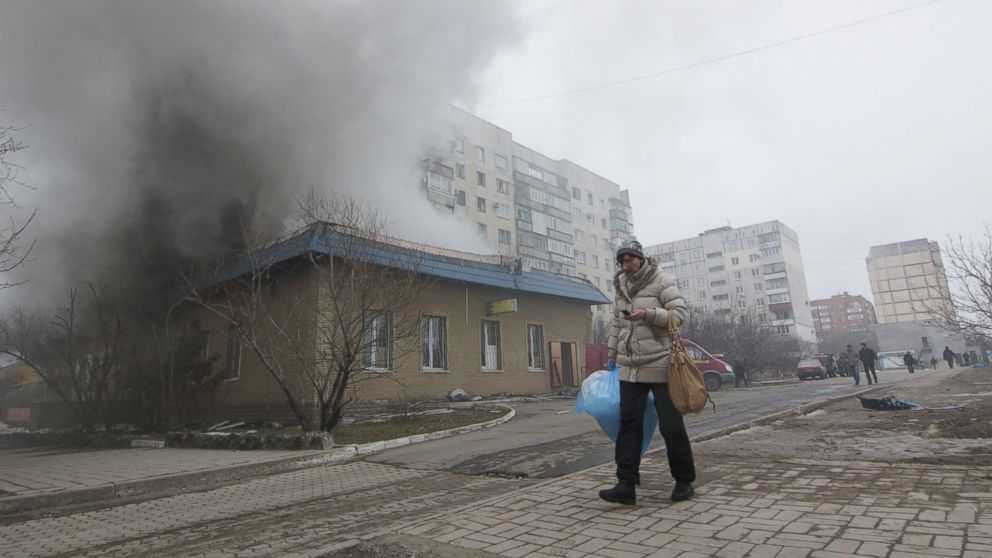 PHOTO: A woman resident passes by a burning house in Mariupol, Ukraine, Saturday, Jan. 24, 2015. 