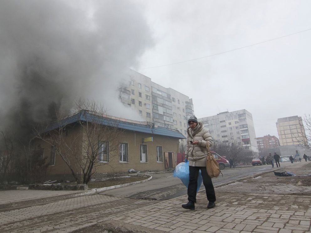 PHOTO: A woman resident passes by a burning house in Mariupol, Ukraine, Saturday, Jan. 24, 2015.
